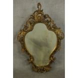 A 19th century Rococo Revival giltwood wall mirror, of cartouche form, the frame ornately carved