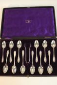 A leather cased set of twelve Edwardian Walker and Hall silver coffee spoons and sugar tongs.