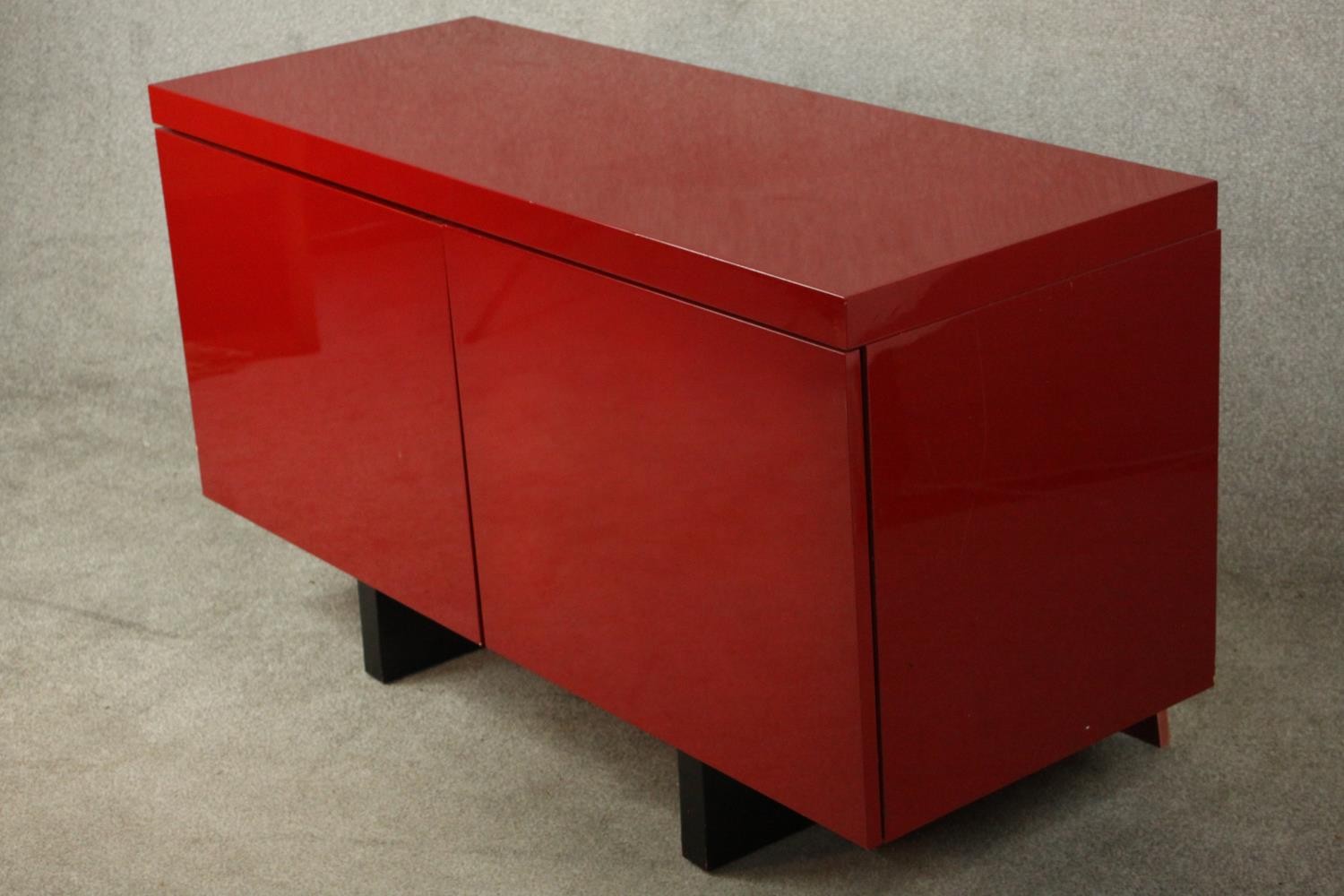 A contemporary red lacquered sideboard with two cupboard doors, on black lacquered supports. H.74 - Image 11 of 14