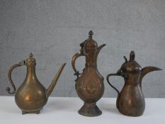 Three copper and brass hinged lidded 19th century Indo-Persian coffee pots with engraved stylised