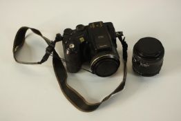 A Fuji S7000 finepix camera and Nikon lens. H.7 W.12 D.11cm