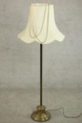 A 20th century standard lamp with a circular brass base and a white shade. H.147 Dia.59cm.