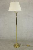 A contemporary brass reading lamp, with an adjustable arm on a cylindrical stem with a circular base