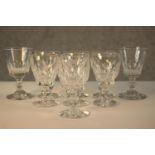 A set of seven 19th century Waterford crystal wine glasses, with cut bowls and a single knop, etched