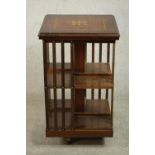 A 20th century marquetry inlaid walnut revolving bookcase, with slatted sides. H.80 W.40 D.40cm.