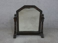 An early 20th century carved oak toilet mirror, on block and turned supports. H.58 W.56 D.19cm (