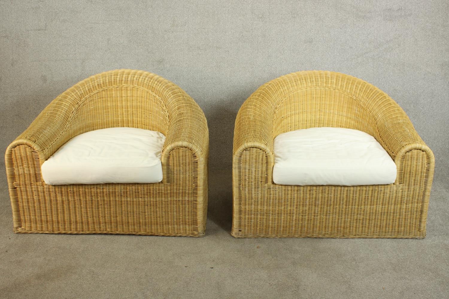 Unopiu, Italy; a pair of large Lloyd Loom type wicker tub chairs, with loose seat cushions. H.72 W.