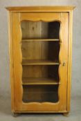 A Continental, probably Scandinavian pine floor standing bookcase, with a glazed door enclosing