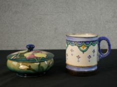 A Moorcroft green pottery circular bowl and cover in the African Lilly pattern along with an Art