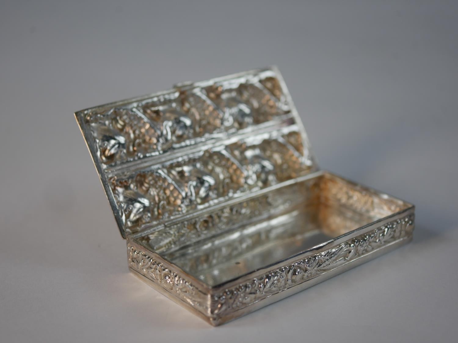 A white metal repousse vine design box with floral and corn motifs to the sides. H.1.5 W.9 D.5cm - Image 3 of 5