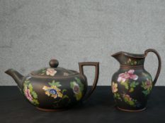 An early 19th century Wedgwood black basalt Capri ware teapot and jug, painted with enamelled