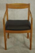 A circa 1960's Mcintosh teak armchair No 4004, with a shaped bar back over open arms and a black