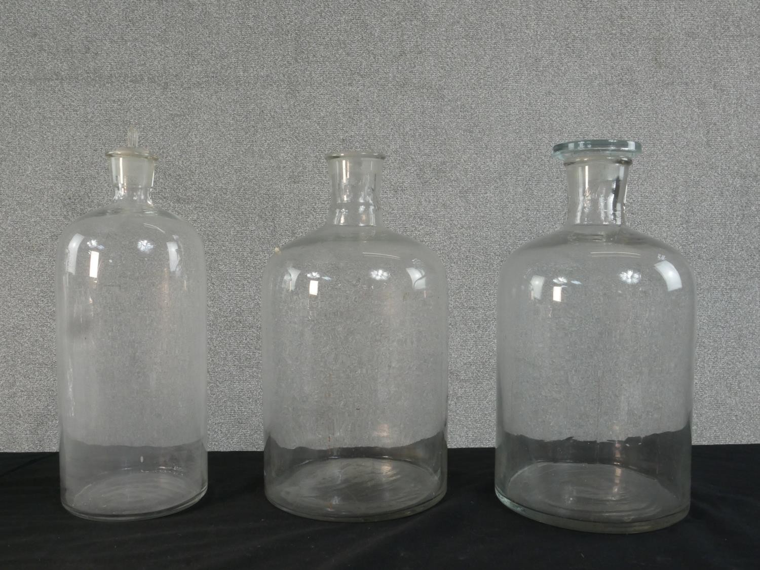 Three clear glass pharmaceutical demijohns along with a pair of cut glass decanters and three - Image 2 of 5