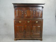 An 18th century oak court cupboard type estate cabinet, with three cupboard doors, the central