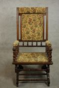 A late 19th / early 20th century American walnut rocking chair, upholstered in tapestry style floral