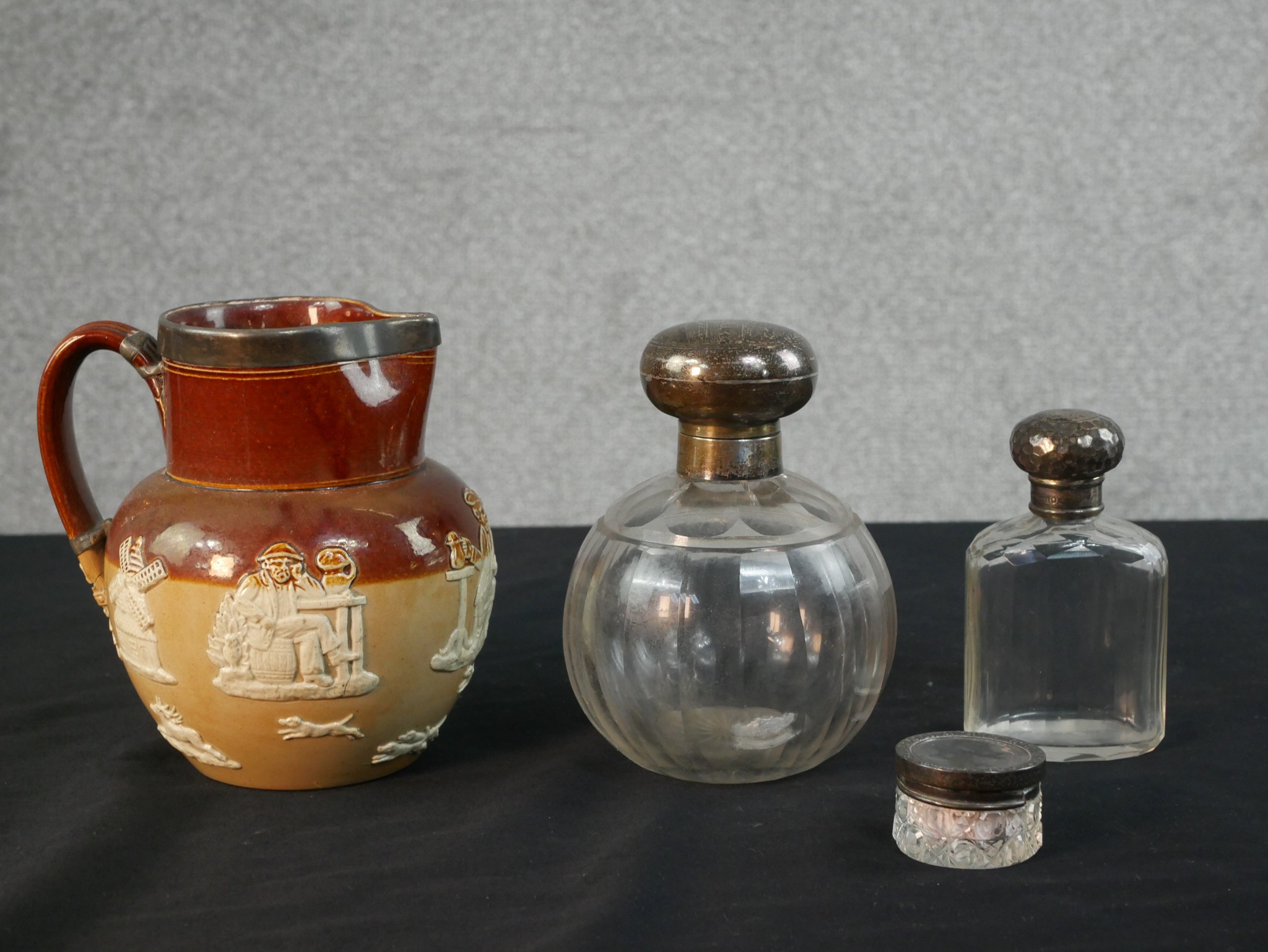 Two Victorian silver topped cut glass perfume bottles, along with a silver topped rouge pot and a