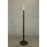 A 20th century stained beech standard lamp, with a turned stem on a circular footed base. H.167