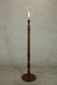 A 20th century stained beech standard lamp, with a turned stem on a circular footed base. H.167