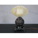 An early 20th century carved coconut design table lamp with silk finned shade on tripod elephant