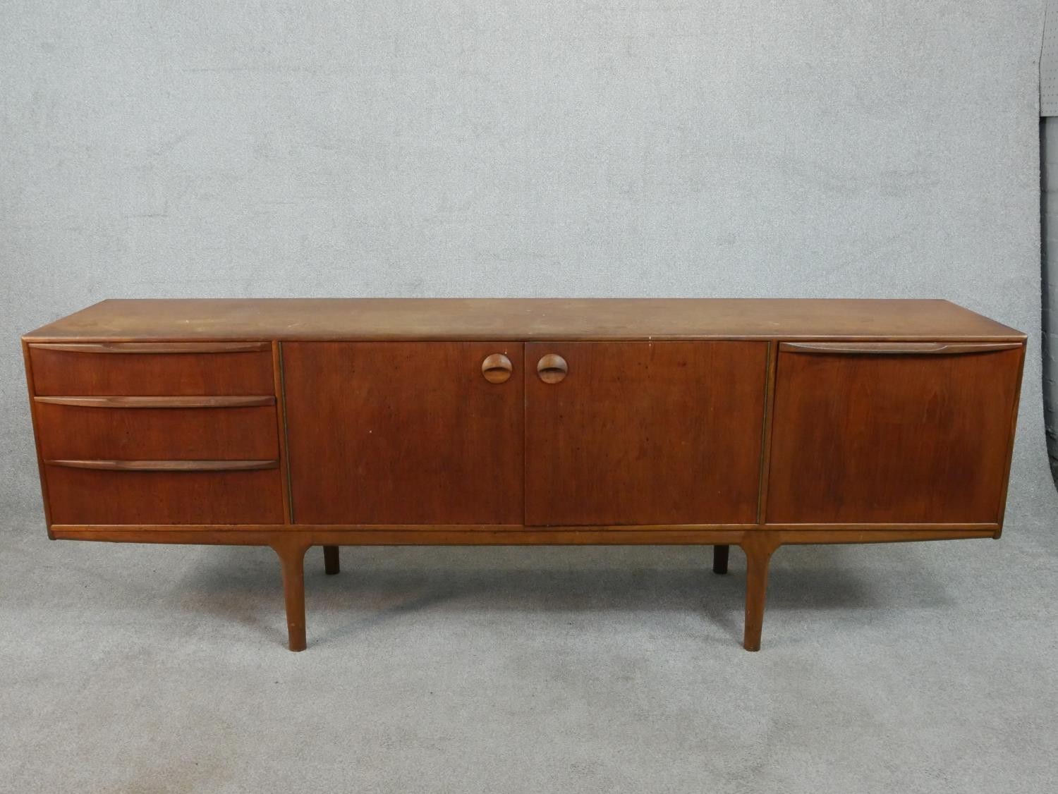 An A. H. McIntosh Ltd circa 1950s teak sideboard, with a pair of cupboard doors, flanked on one side