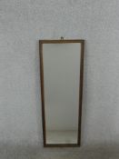 An early 20th century oak framed wall mirror of elongated form. H.96 W.34cm