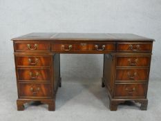 A Georgian style flame mahogany three section pedestal desk with tooled leather insert above an