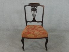 A late Victorian walnut side chair, with an ornately carved and pierced back splat, the seat