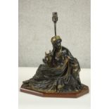 An Egyptian revival gilded bronze figural table lamp depicted as a female in flowing robes holding a