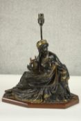 An Egyptian revival gilded bronze figural table lamp depicted as a female in flowing robes holding a