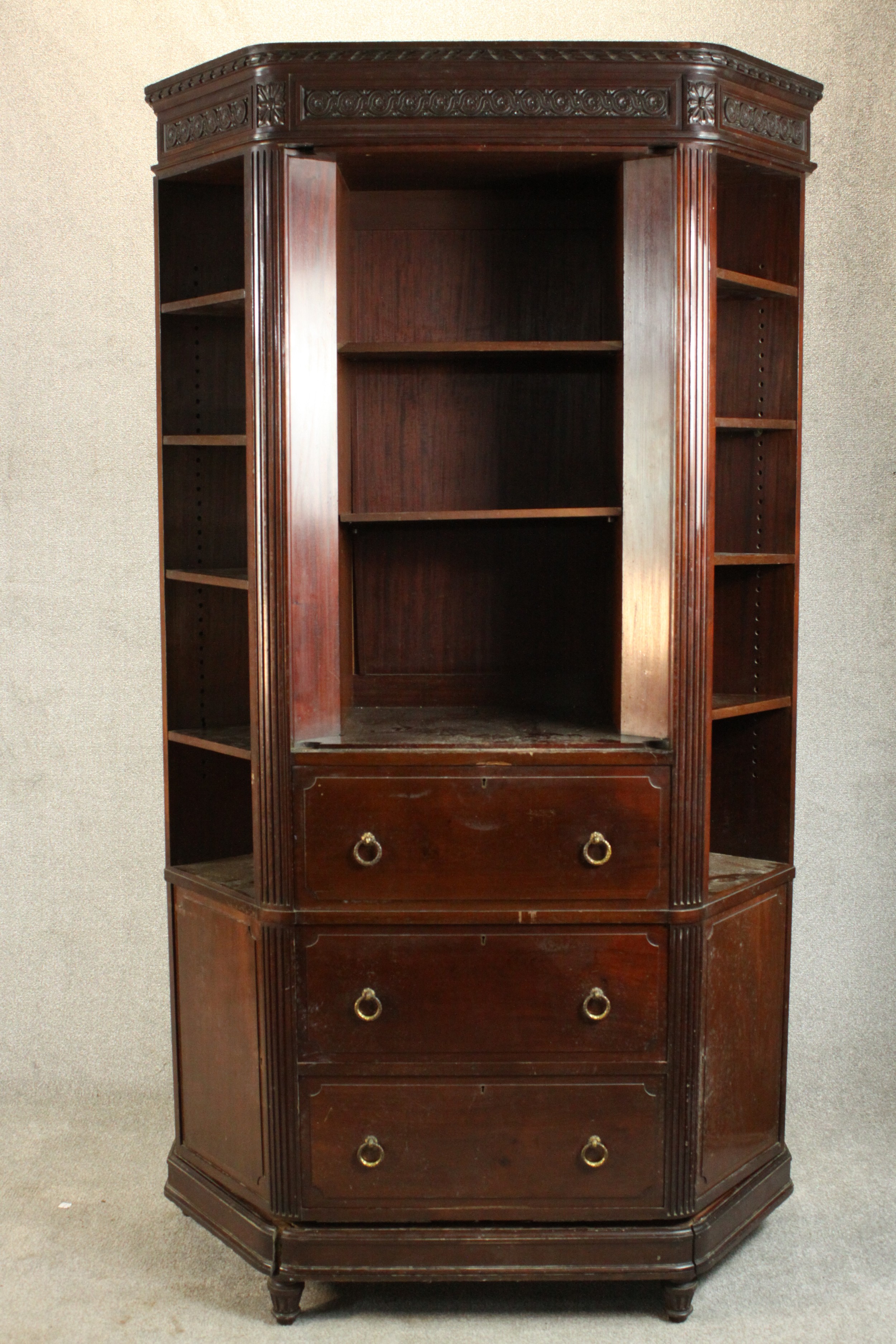 A Continental walnut bookcase with open shelves above drawers on tapering reeded supports. (back