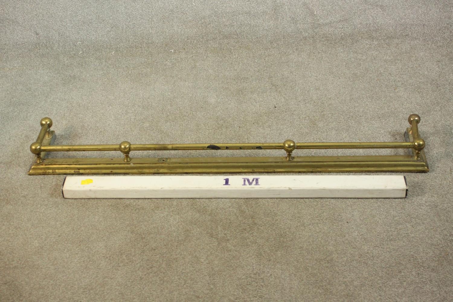 A Victorian brass fender of typical form with ball supports to the tubular rail. H.10 W.123 D.20cm. - Image 2 of 5