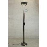 A contemporary floor standing uplighter lamp, with a reading lamp on an adjustable arm, on a