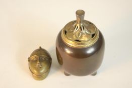 A Japanese bronze incense burner with gilded pierced lid in the form of a fruit on three splayed