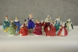 A collection of eleven hand painted porcelain figures of ladies in a variety of coloured dresses