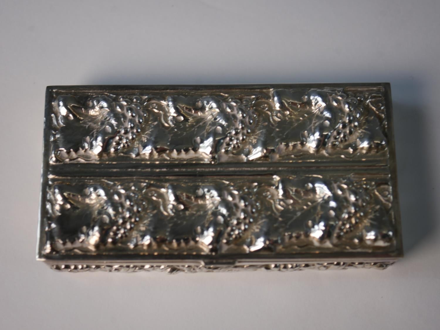 A white metal repousse vine design box with floral and corn motifs to the sides. H.1.5 W.9 D.5cm - Image 2 of 5