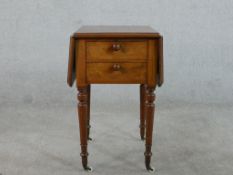 A Victorian walnut work table, with two drop leaves over a fall front, a dummy drawer to the other
