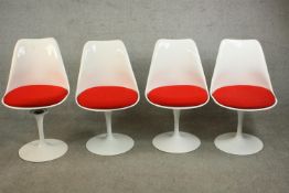 After Eero Saarinen, a set of four Tulip chairs, with white plastic shells and loose red upholstered