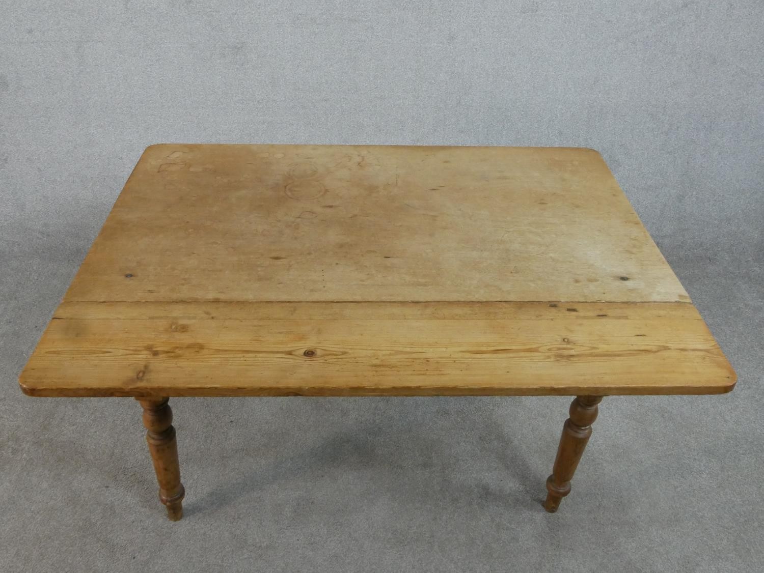 A Victorian pine kitchen table, with one drop leaf over end drawers, on turned legs. H.71 W.109 - Image 6 of 7