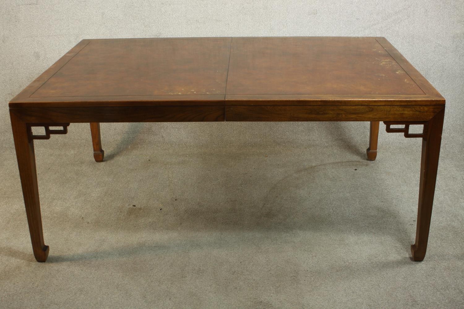 A late 20th century Chinese hardwood extending dining table, of rectangular form with two additional