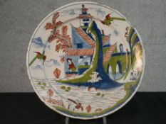 An 18th century English Delft tin glazed earthenware plate, possibly Bristol, polychrome painted