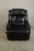 A late 20th century black leather reclining armchair, with padded seat and back cushions and a