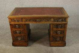 A Vicrorian oak pedestal desk, with a tooled burgundy leather writing insert, over an arrangement of