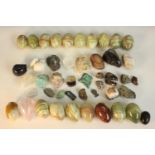 A collection of gemstones and minerals, including seventeen alabaster eggs, a rose quartz drop, iron