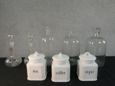 Three clear glass pharmaceutical demijohns along with a pair of cut glass decanters and three