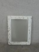 A white painted and distressed rectangular pine wall mirror, with a moulded frame. H.90 W.70cm