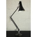A mid 20th century Herbert Terry style anglepoise desk lamp, in black with a circular base. H.34