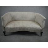 A late 19th/early 20th century two seater sofa, upholstered in patterned ivory fabric, on mahogany