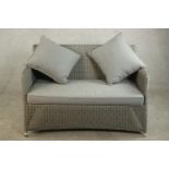 A contemporary grey painted Lloyd Loom style two seater sofa, with loose grey upholstered seat