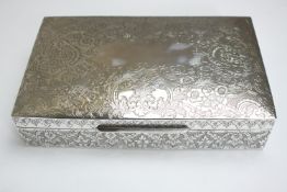 A large cedar lined white metal (tests as silver) cigarette box with an all over engraved flora