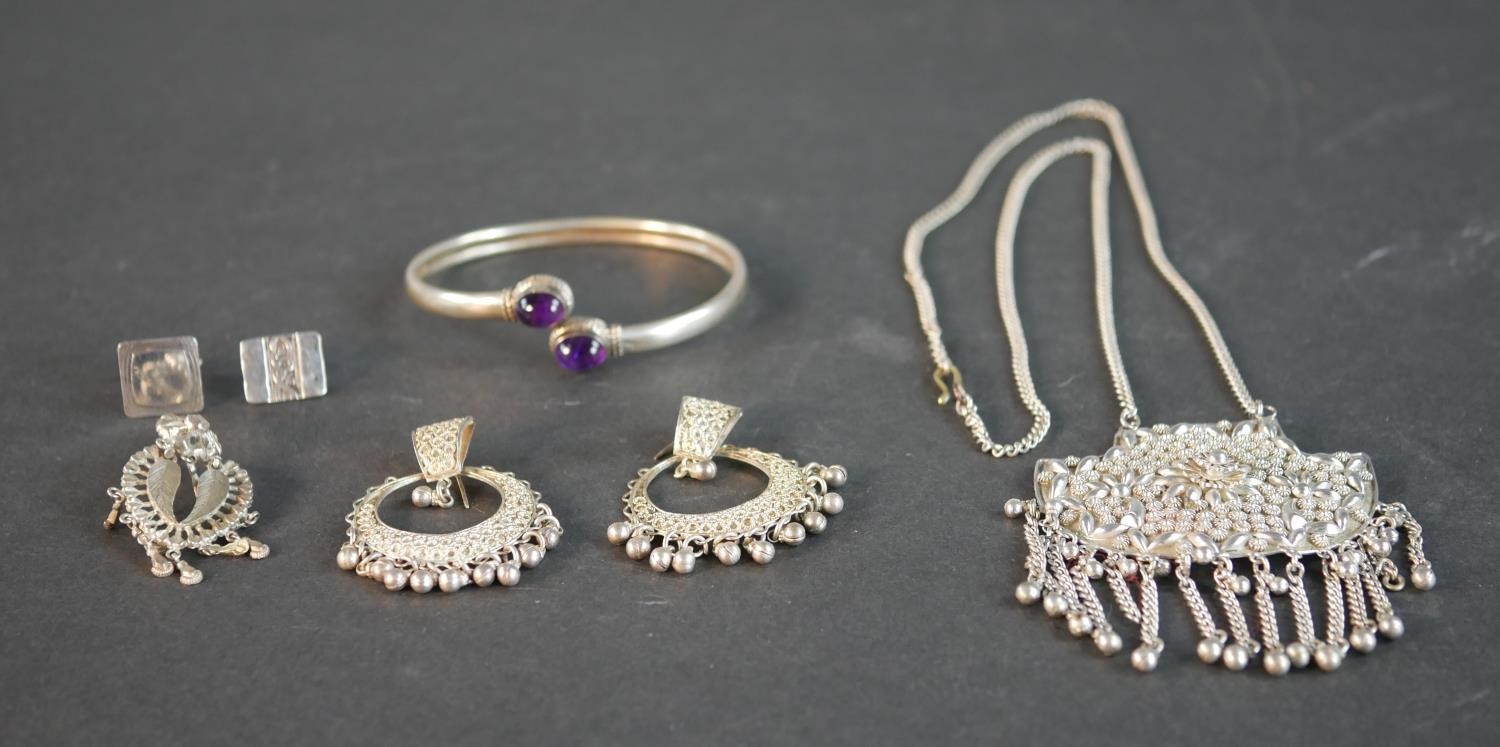 A collection of silver and white metal jewellery, including an amethyst cabochon bangle, an Indian